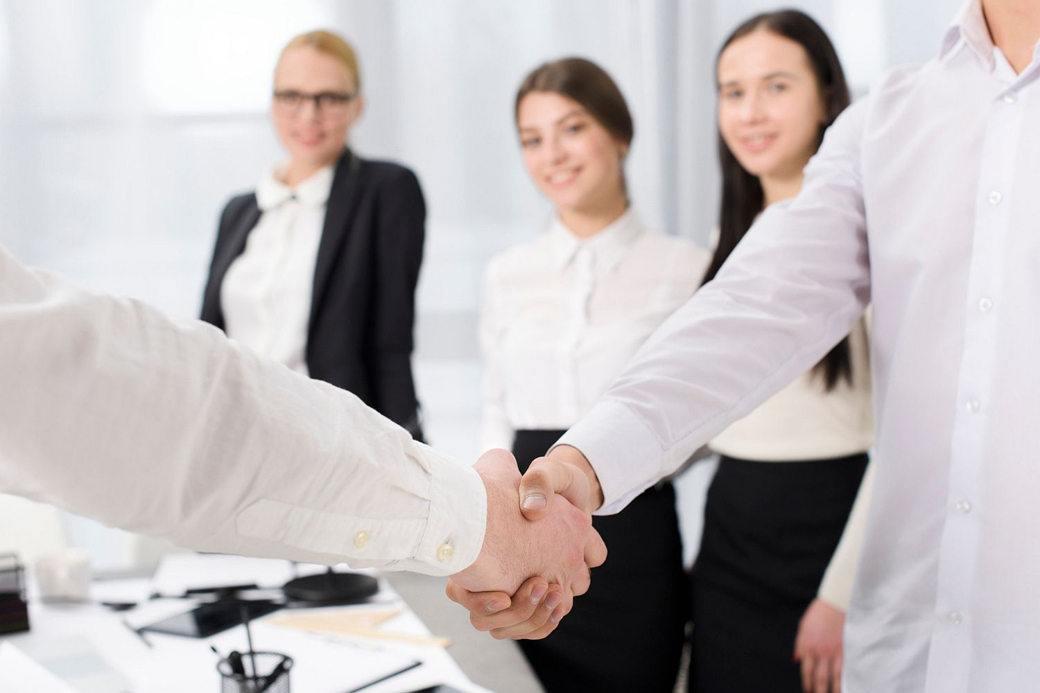 two business partners shaking hands office